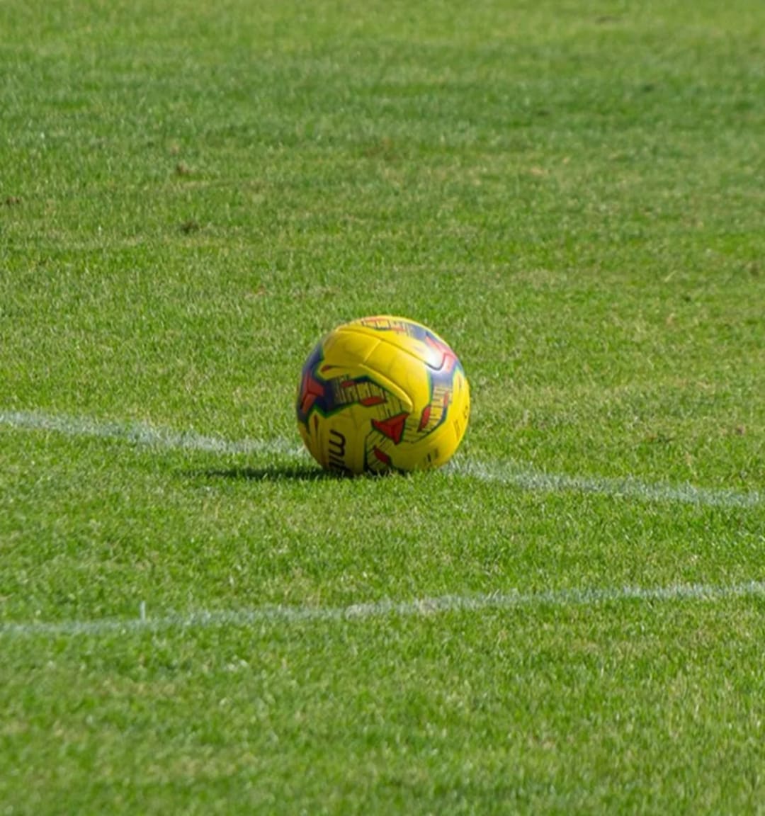 A soccer ball resting on the pitch, ready for kickoff